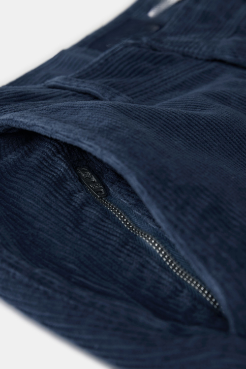 NOBEL Donkerblauwe Corduroy Broek voor Mannen met ribbelstructuur, elastische tailleband, rits- en knoopsluiting, en functionele achterzakken met magneetsluiting.