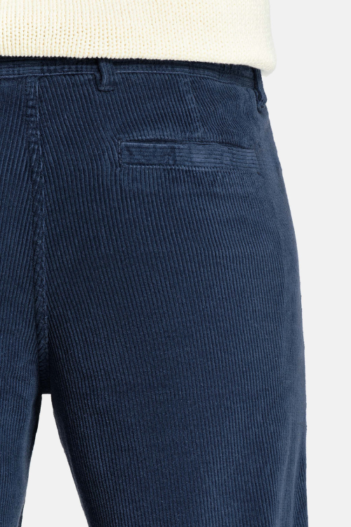 NOBEL Donkerblauwe Corduroy Broek voor Mannen met ribbelstructuur, elastische tailleband, rits- en knoopsluiting, en functionele achterzakken met magneetsluiting.